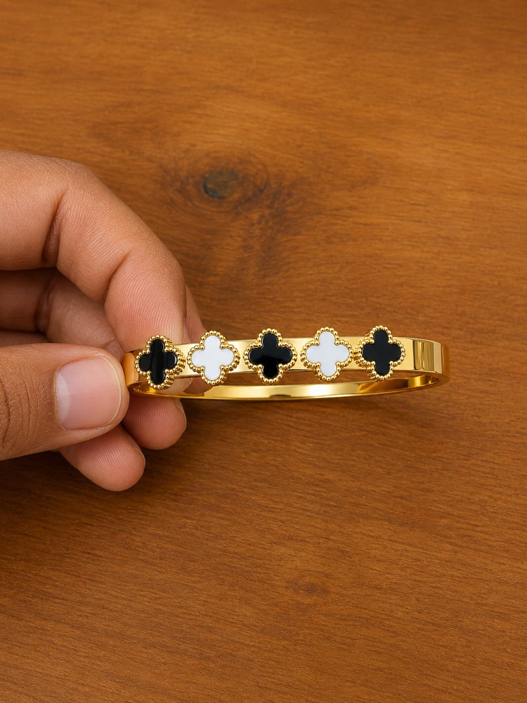 Black Clover Cuff Bracelet in gold-tone style with alternating black and white clover motifs across the cuff
