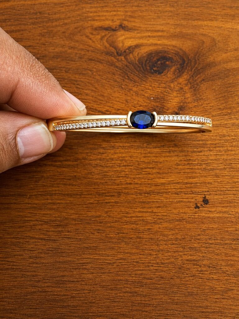 Blue Stone Bar Bracelet in gold-tone style with a deep blue round centre on a slim clear-accent bar