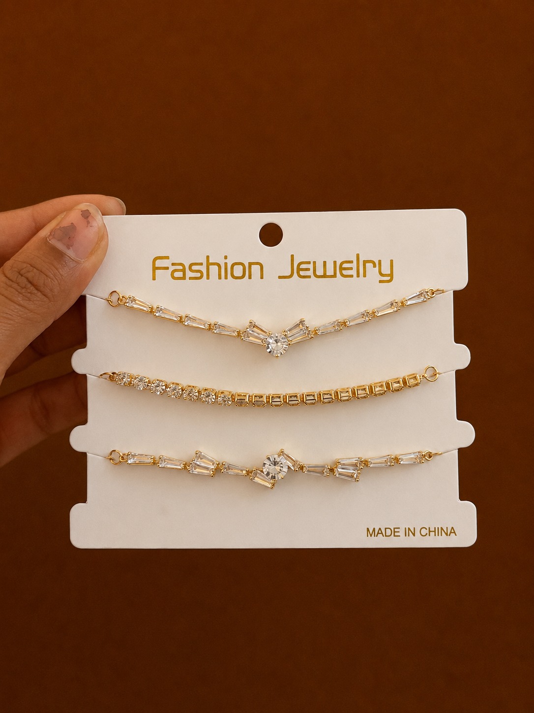 Set of 3 Geometric Chain Bracelets in gold-tone style with three fine bracelets with diamond and bar-shaped accents
