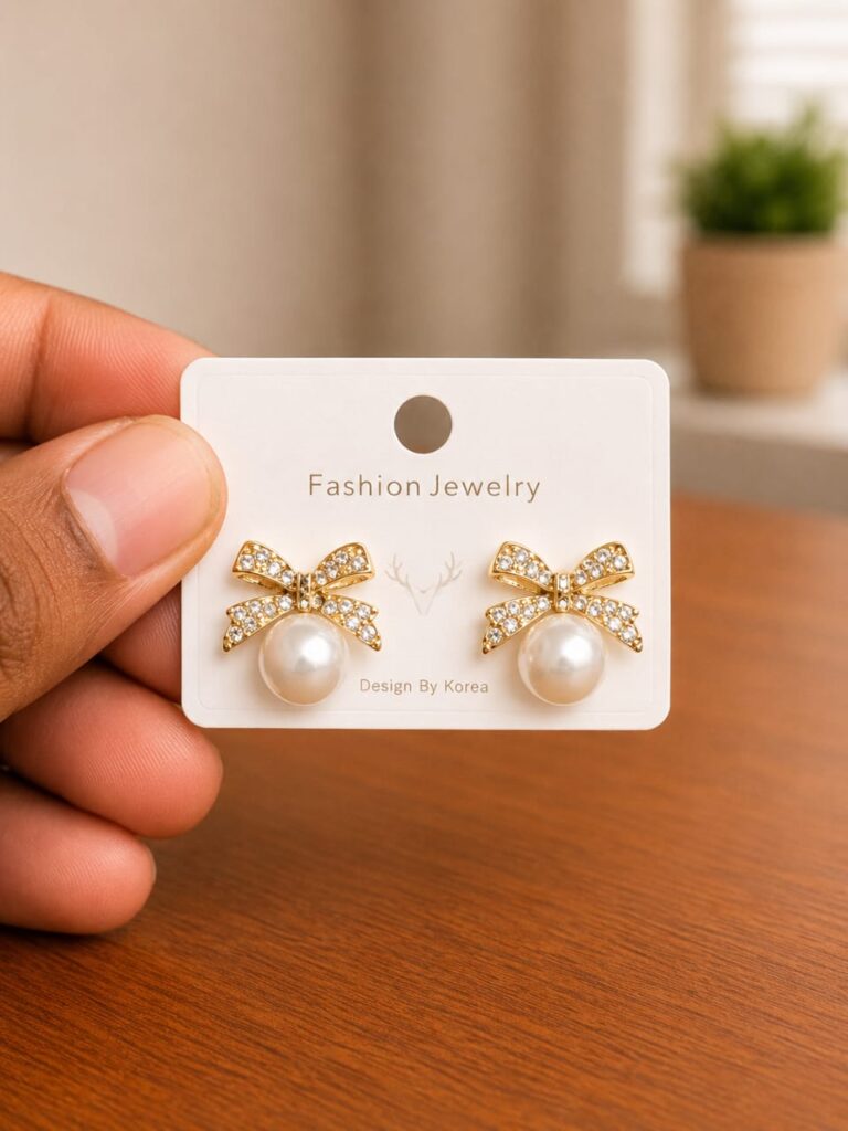 Clear Bow Pearl Stud Earrings in gold-tone style with clear bow motifs set above pearl-like centres