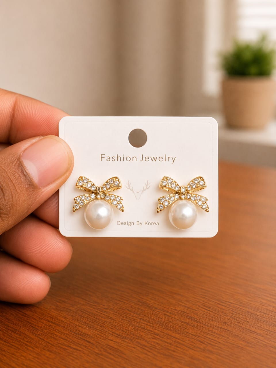 Clear Bow Pearl Stud Earrings in gold-tone style with clear bow motifs set above pearl-like centres