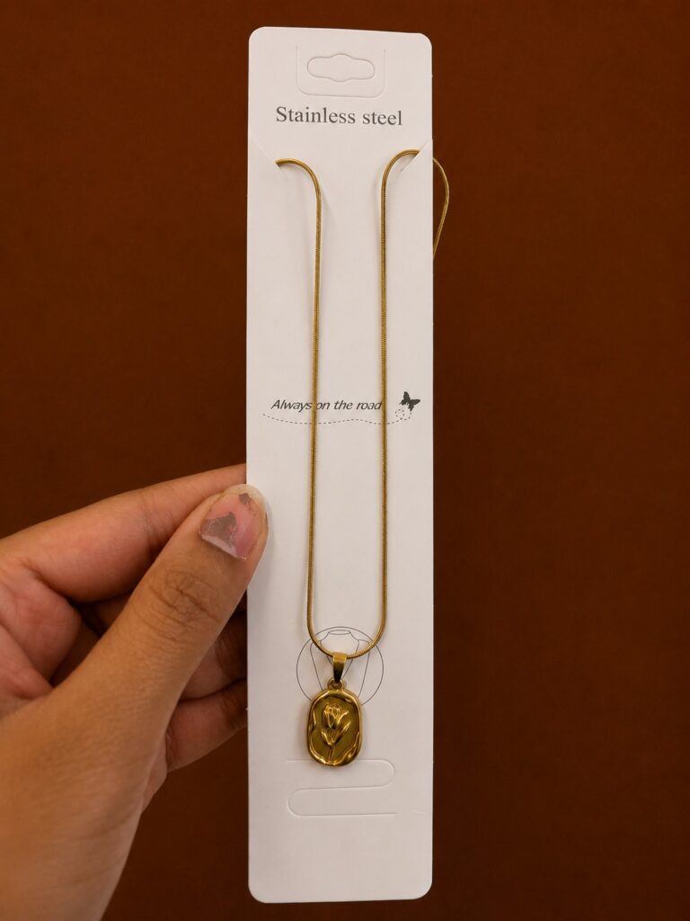 Gold-tone tulip necklace with an embossed oval medallion