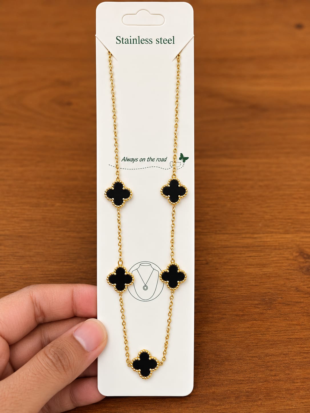 Gold-tone necklace with five black clover motifs