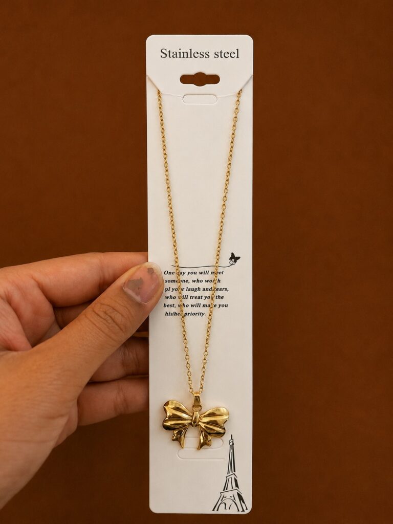 Gold-tone bow pendant necklace with sculpted ribbon detail