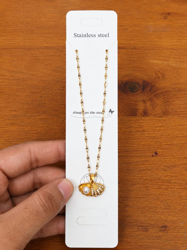 Gold-tone shell necklace with a central pearl-like bead and clear stones