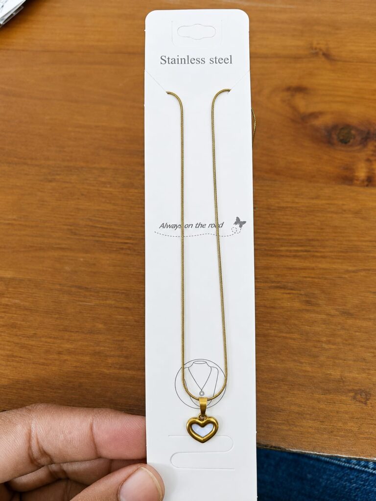 Gold-tone open heart pendant necklace with a pale blue center