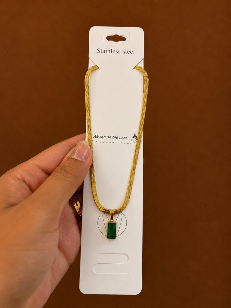 Gold-tone necklace with a rectangular green stone pendant