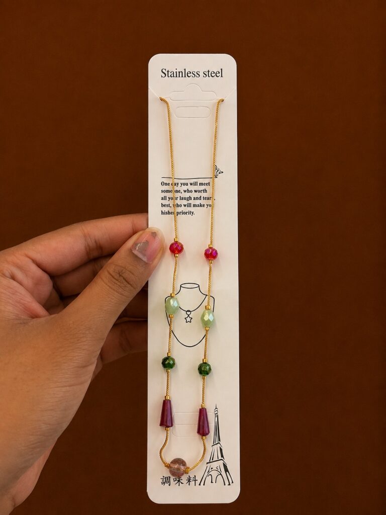 Gold-tone necklace with multicolor bead stations and faceted drops